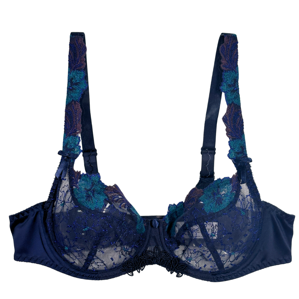 A navy blue lace bra with teal floral embroidery and sheer mesh cups, shown against a plain white background.