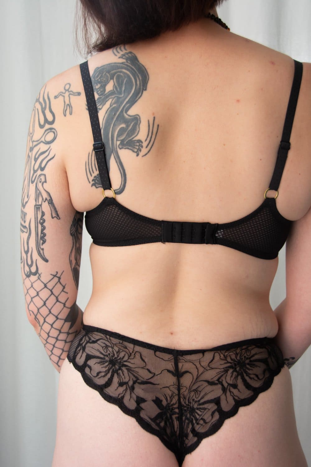 Chantelle Fleurs thong in black, back view on a model.