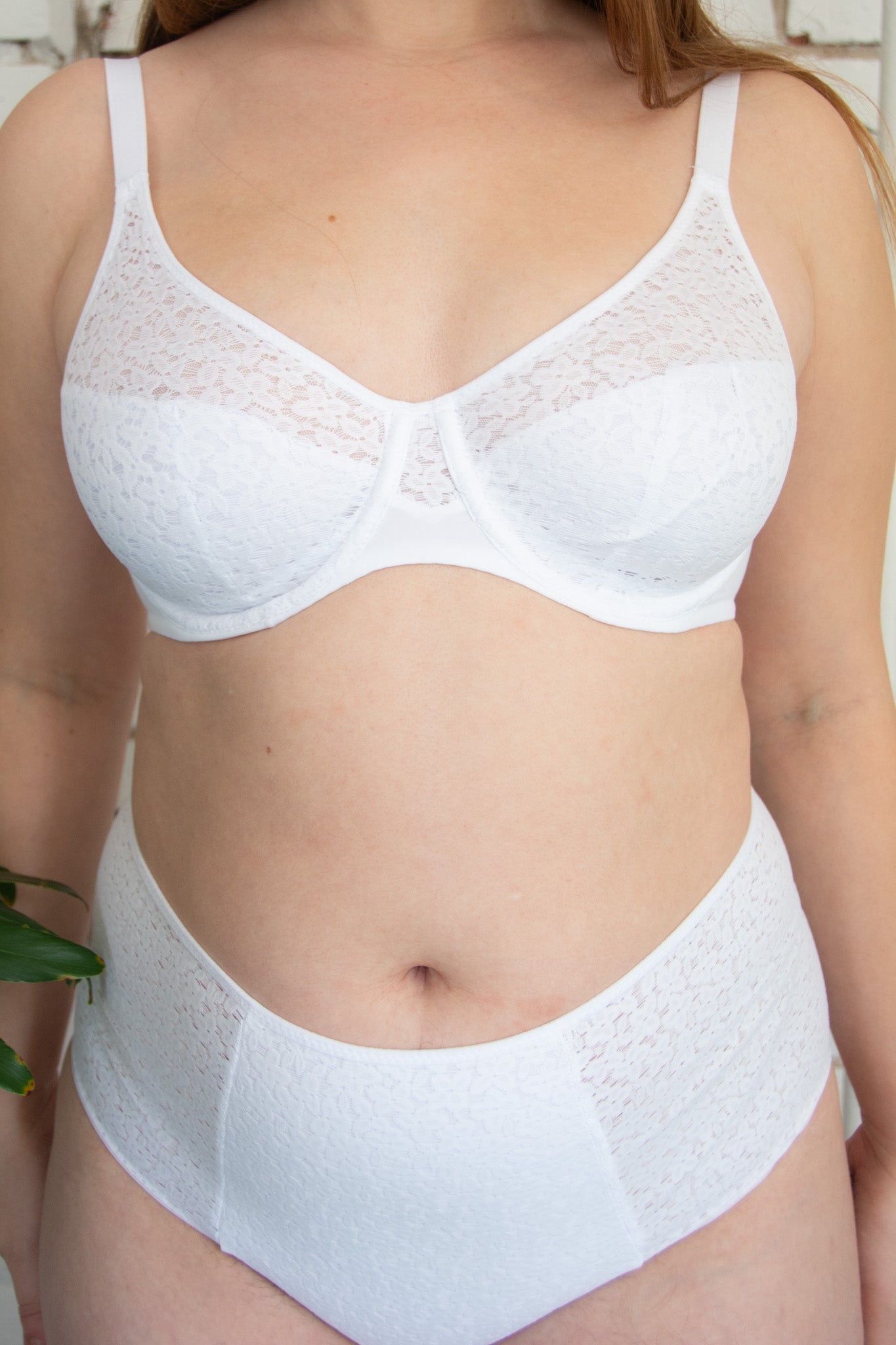 White lace bra and panties set worn by a person.