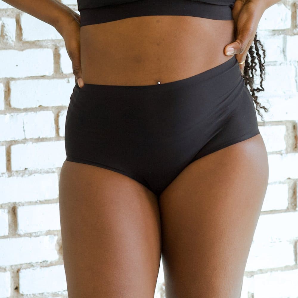 Chantelle soft stretch high rise brief in black, front view on a model, close-up.