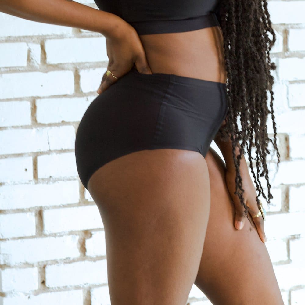 Chantelle soft stretch high rise brief in black, side view on a model, close-up.