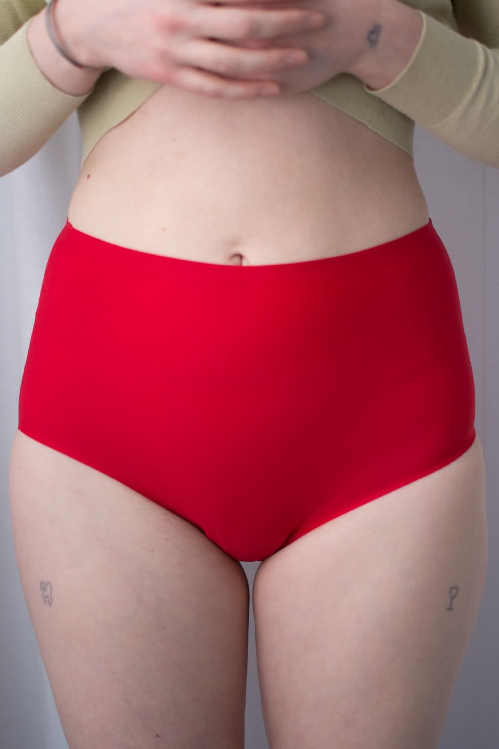 Chantelle soft stretch high rise brief in poppy red, front view on a model, close-up.