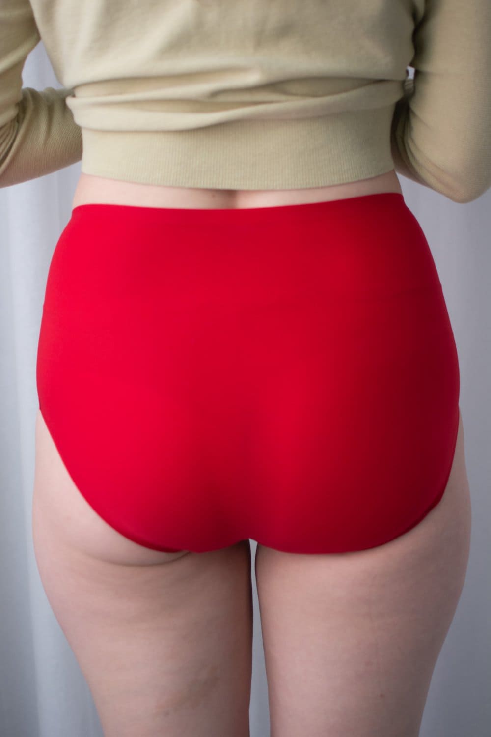 Chantelle soft stretch high rise brief in poppy red, back view on a model, close-up.