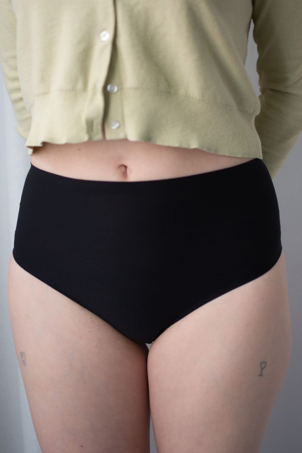 Chantelle soft stretch high waist thong in black, front view on a model, close-up.