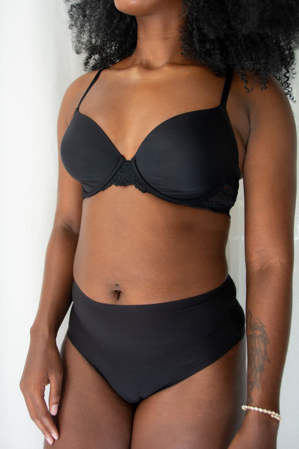 Chantelle soft stretch high waist thong in black, front view on a model on a white background.