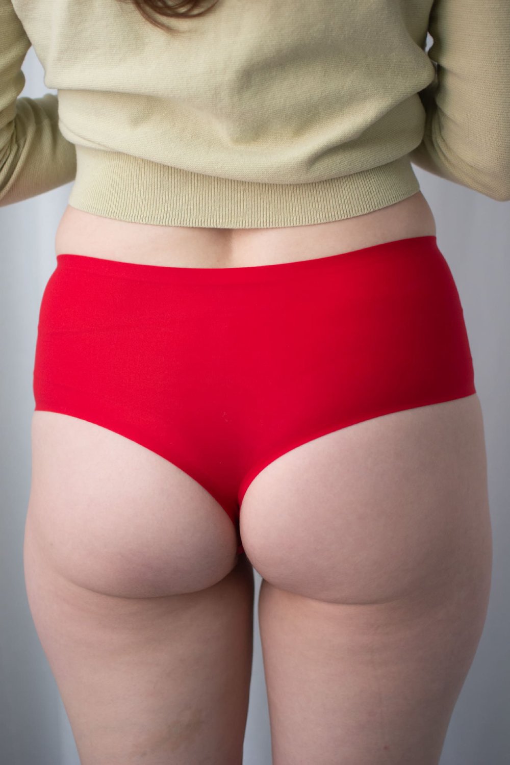 Chantelle soft stretch high waist thong in poppy red, back view on a model, close-up.