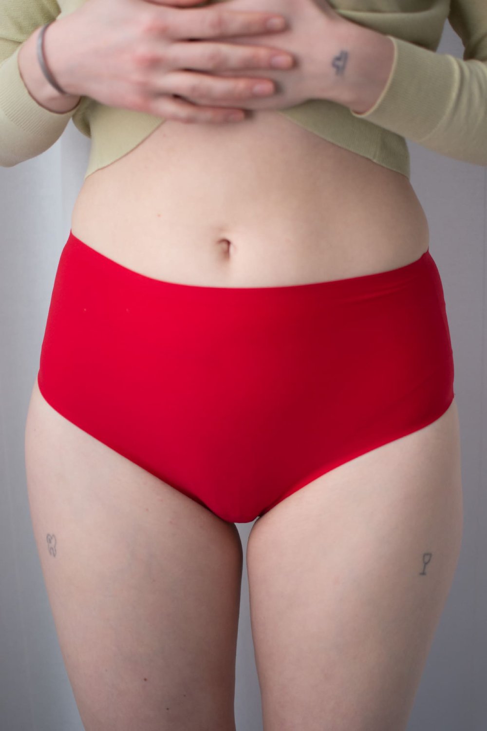 Chantelle soft stretch high waist thong in poppy red, front view on a model, close-up.