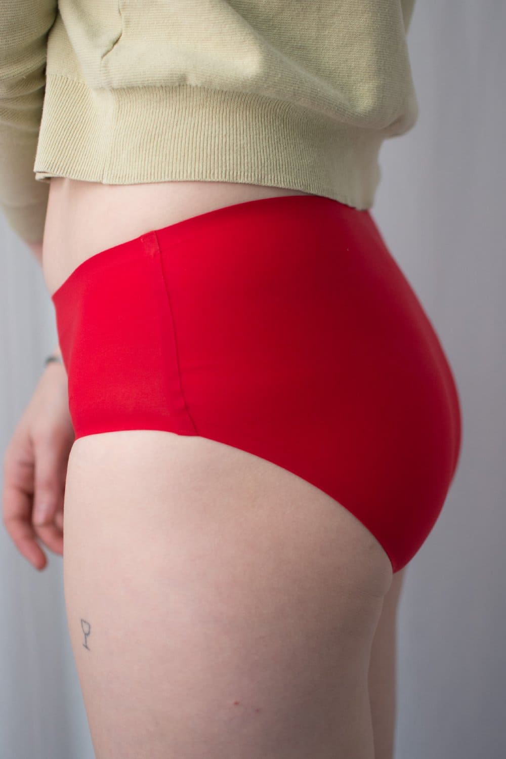 Chantelle soft stretch hipster in poppy red, side close-up on a model.