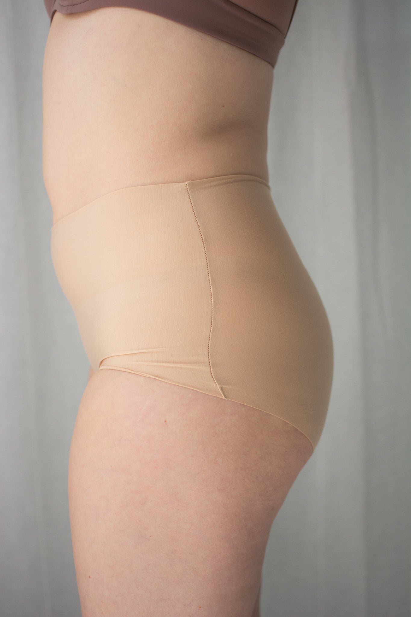 Beige shapewear worn by a person against a neutral background