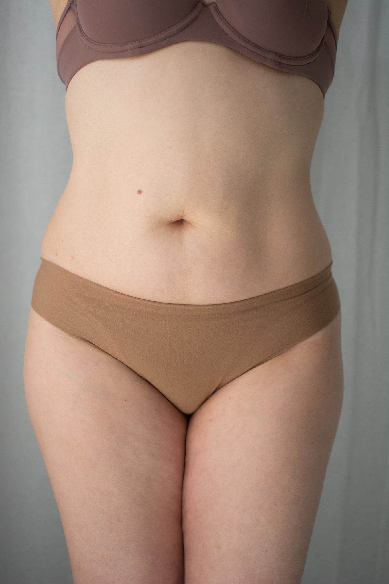 Person wearing a brown bikini against a neutral background