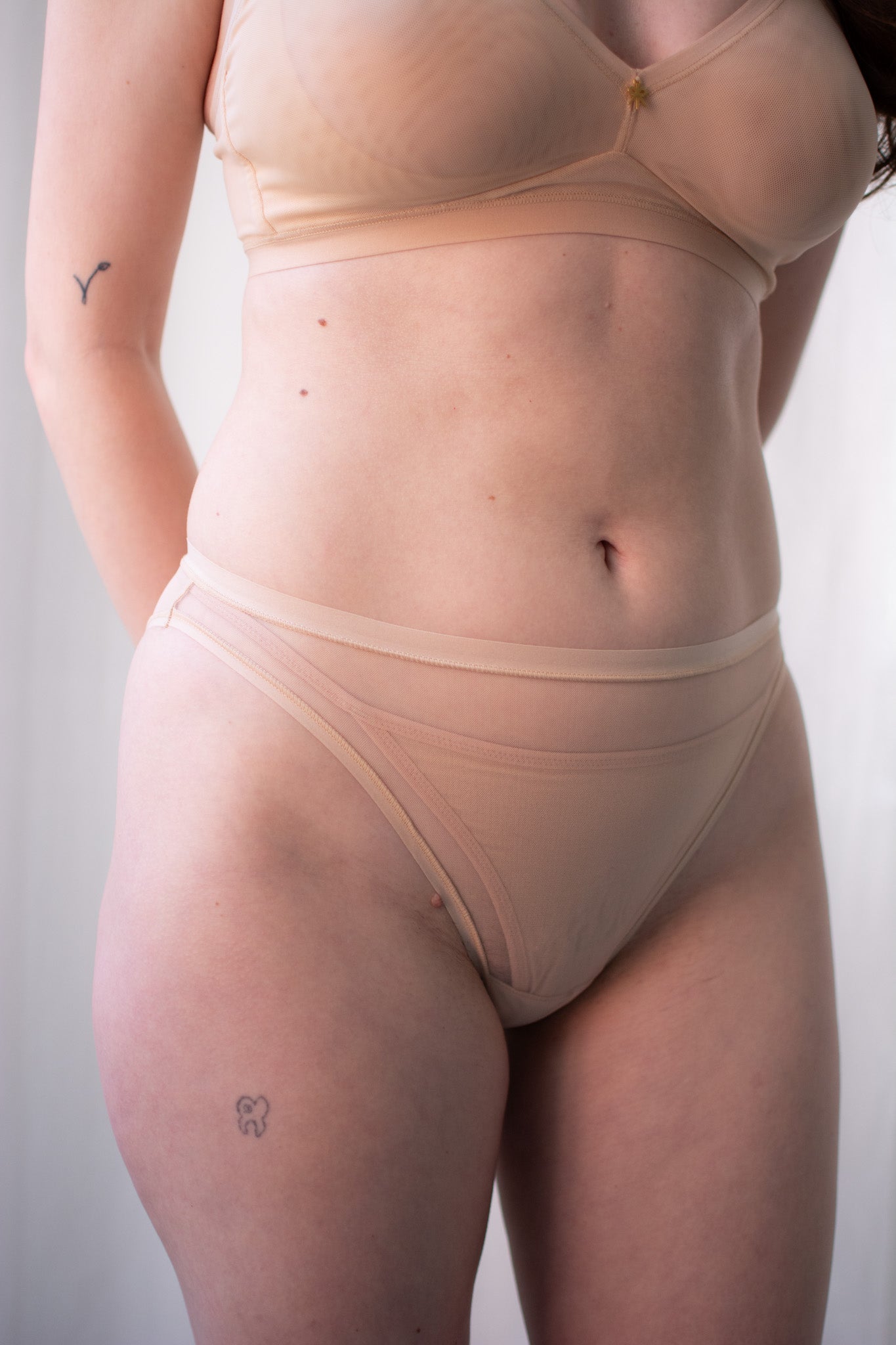 Person wearing a beige shapewear garment against a plain background