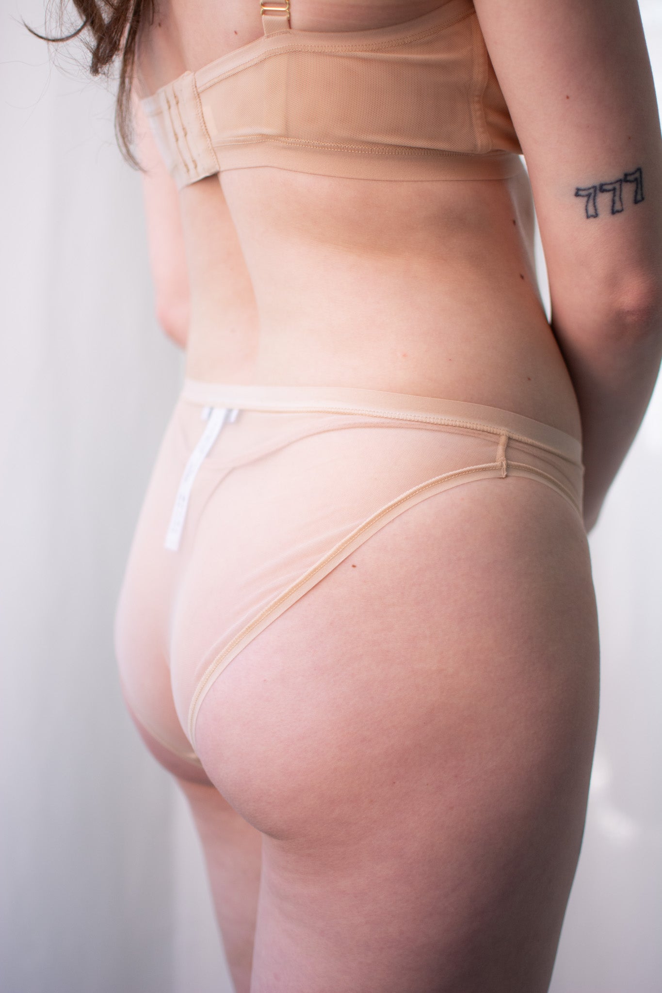 Person wearing beige shapewear against a plain background