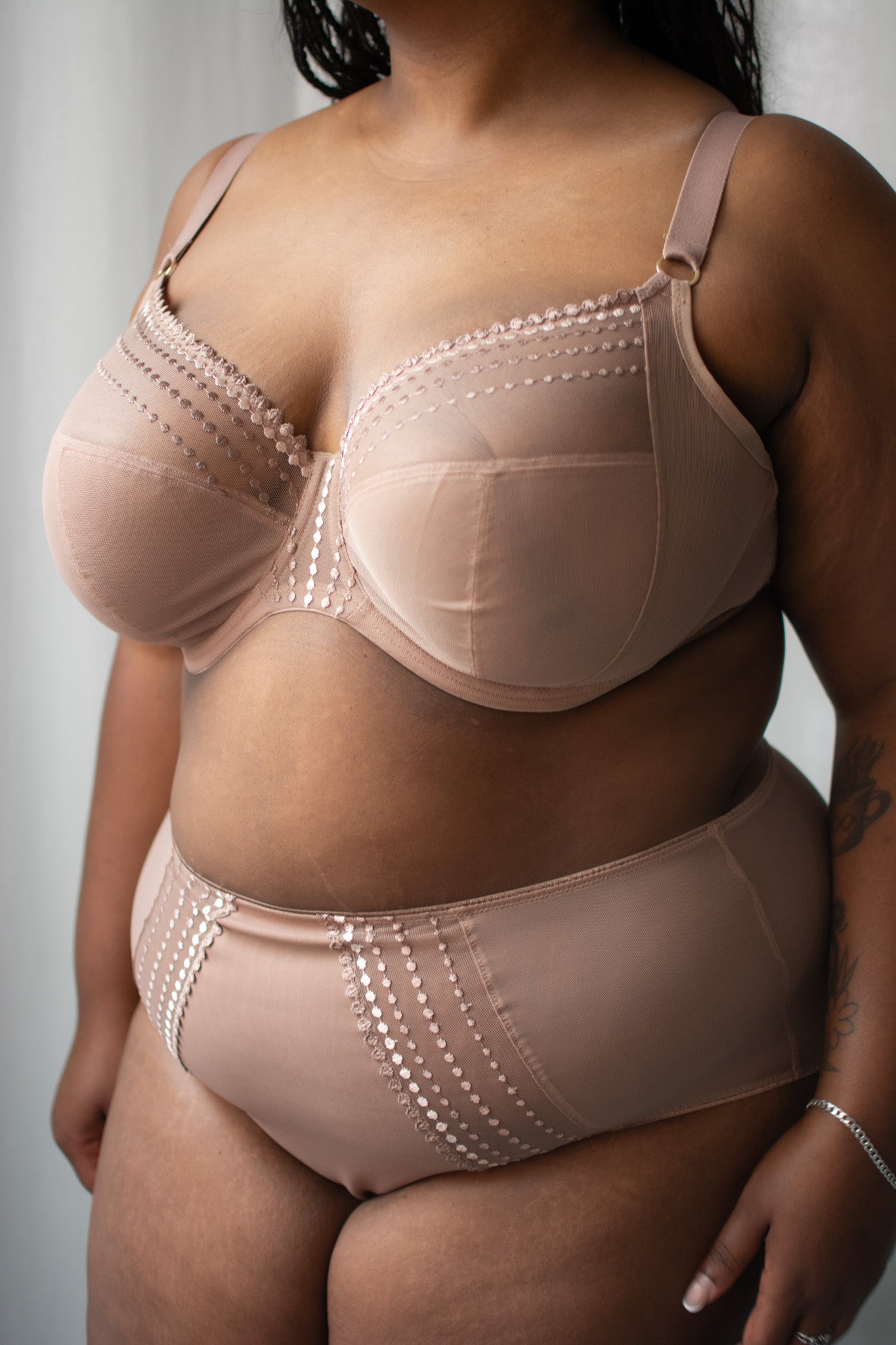 Person wearing a beige shapewear garment against a neutral background