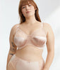 A plus-size model wearing a light pink satin bra and matching panties with delicate lace detailing, set against a plain light gray background.
