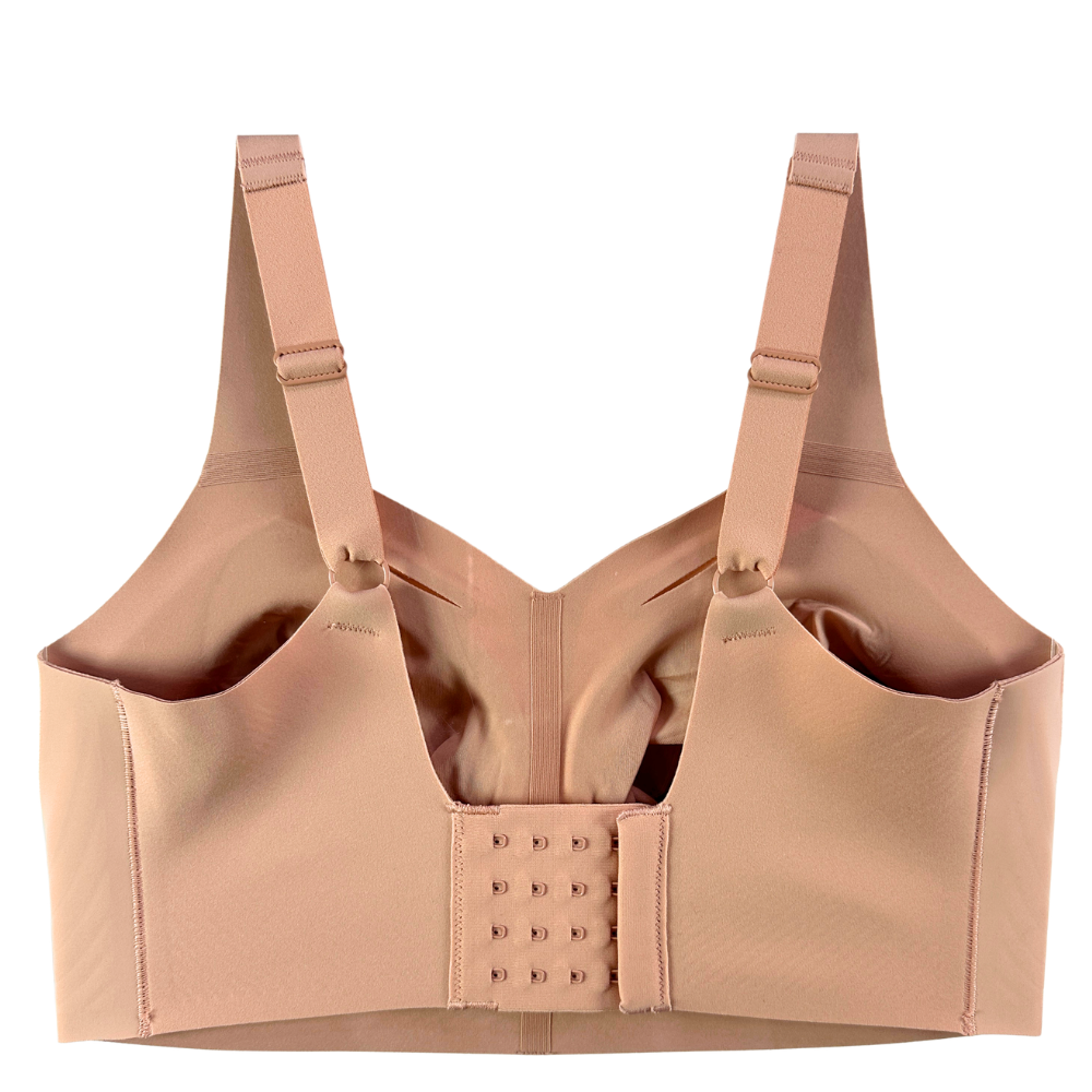A beige wireless nursing bra with wide adjustable shoulder straps, a center gore, and a hook-and-eye back closure, shown against a plain white background.