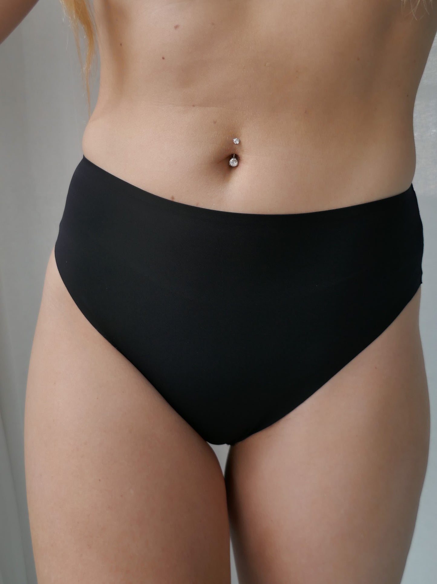 Person wearing black high waist underwear.