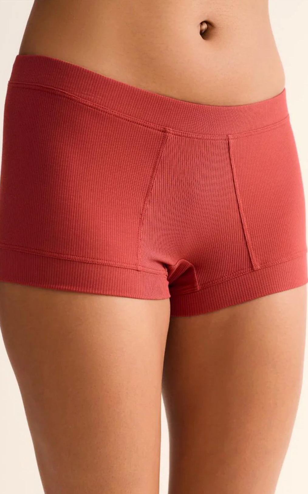 Red ribbed shorts worn by a person on a beige background
