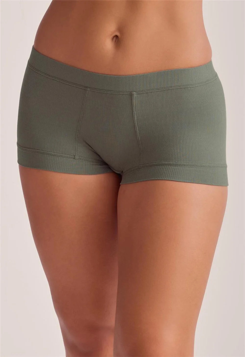 A close-up of a model wearing ribbed green-brown briefs against a plain light background.