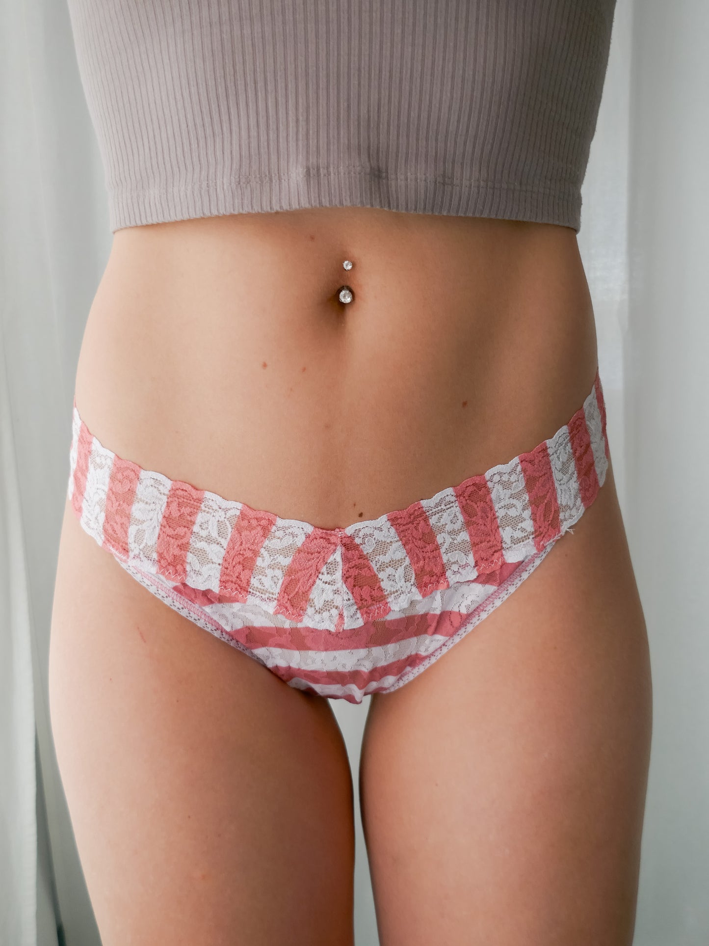 Person wearing red and white striped underwear with a neutral background