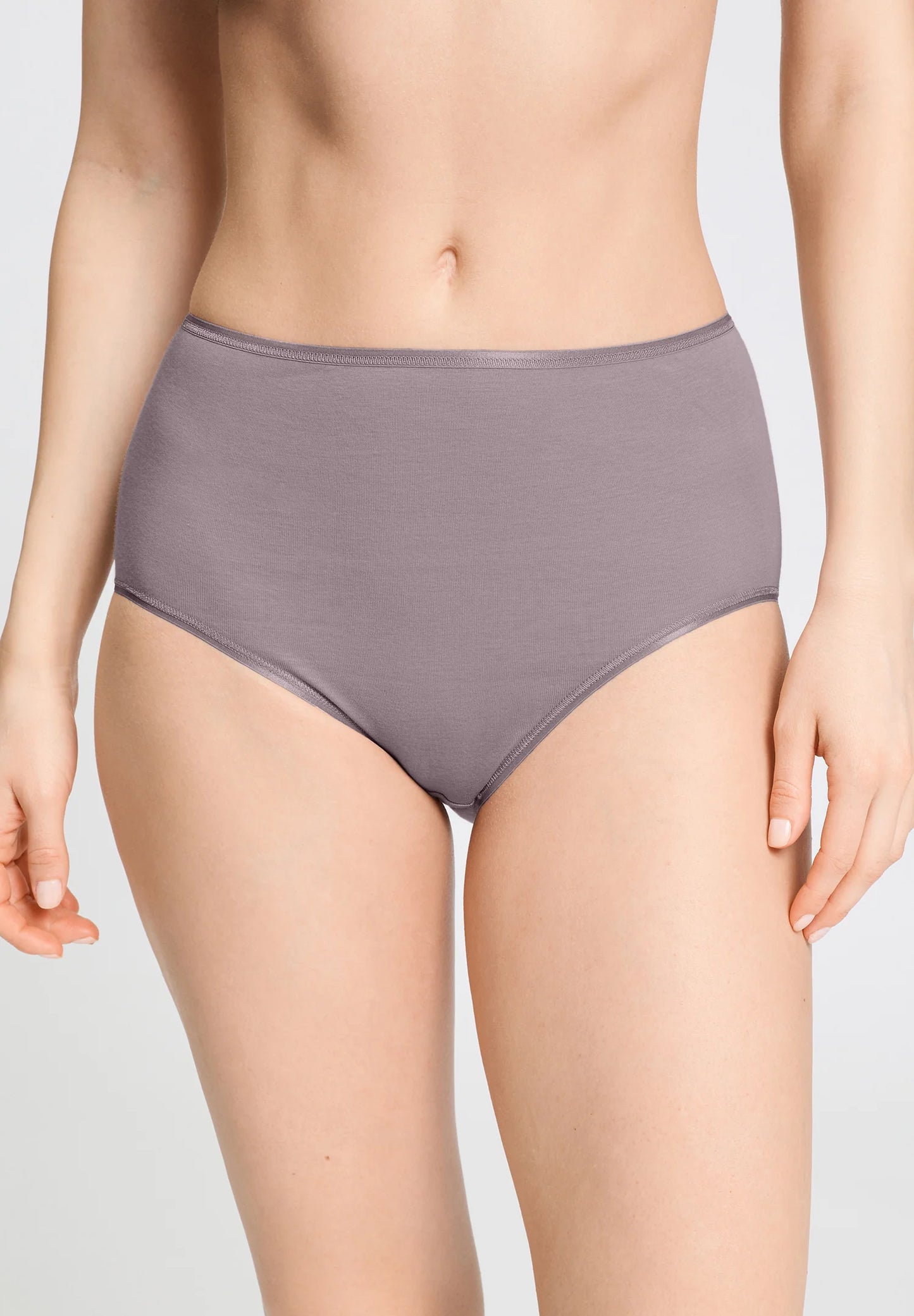 Person wearing a pair of high-waisted purple underwear on a plain background