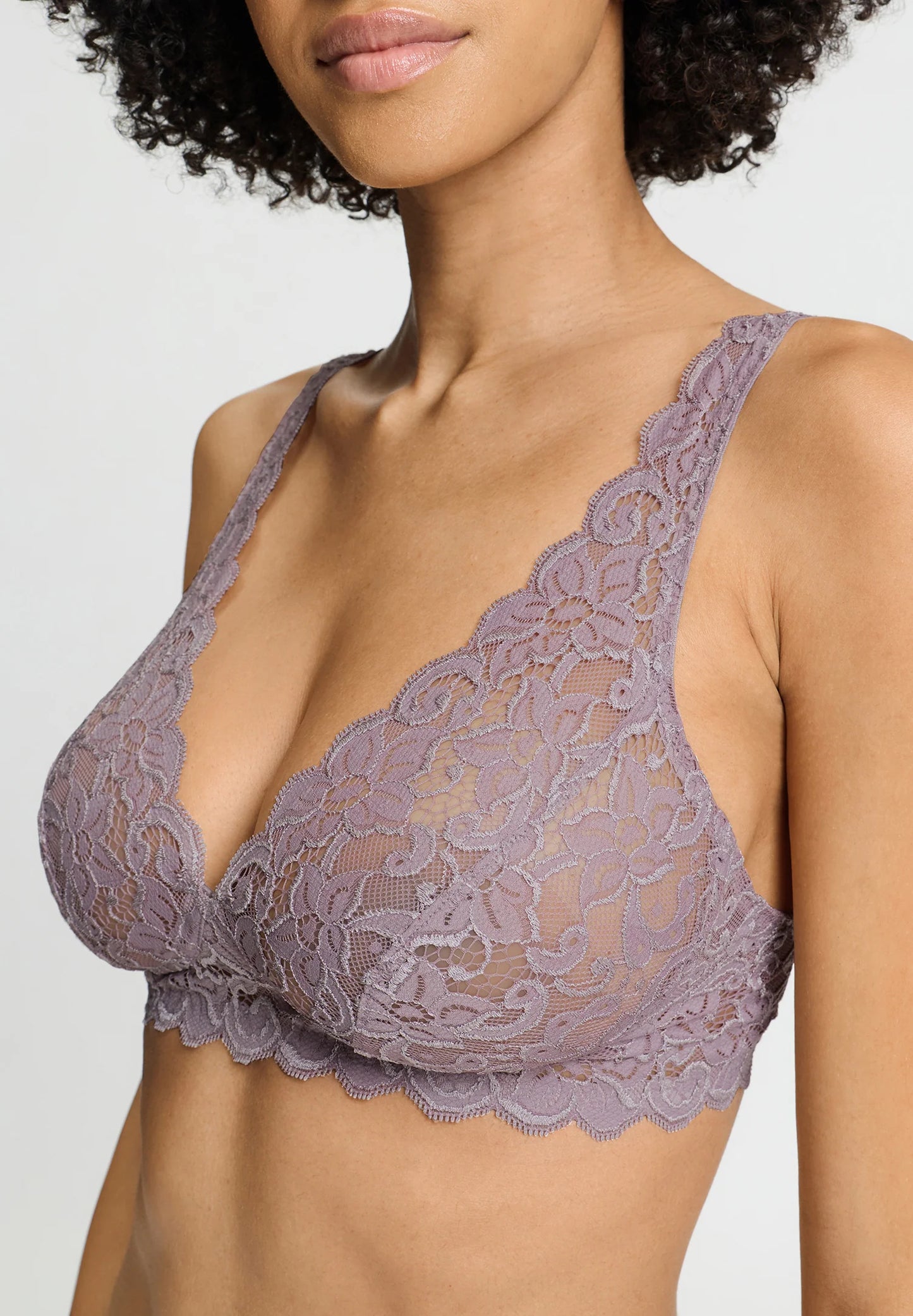 Model in a full-cup, dusty pink, lace bralette. 