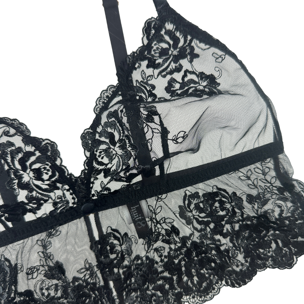 Black lace lingerie with floral designs on a white background