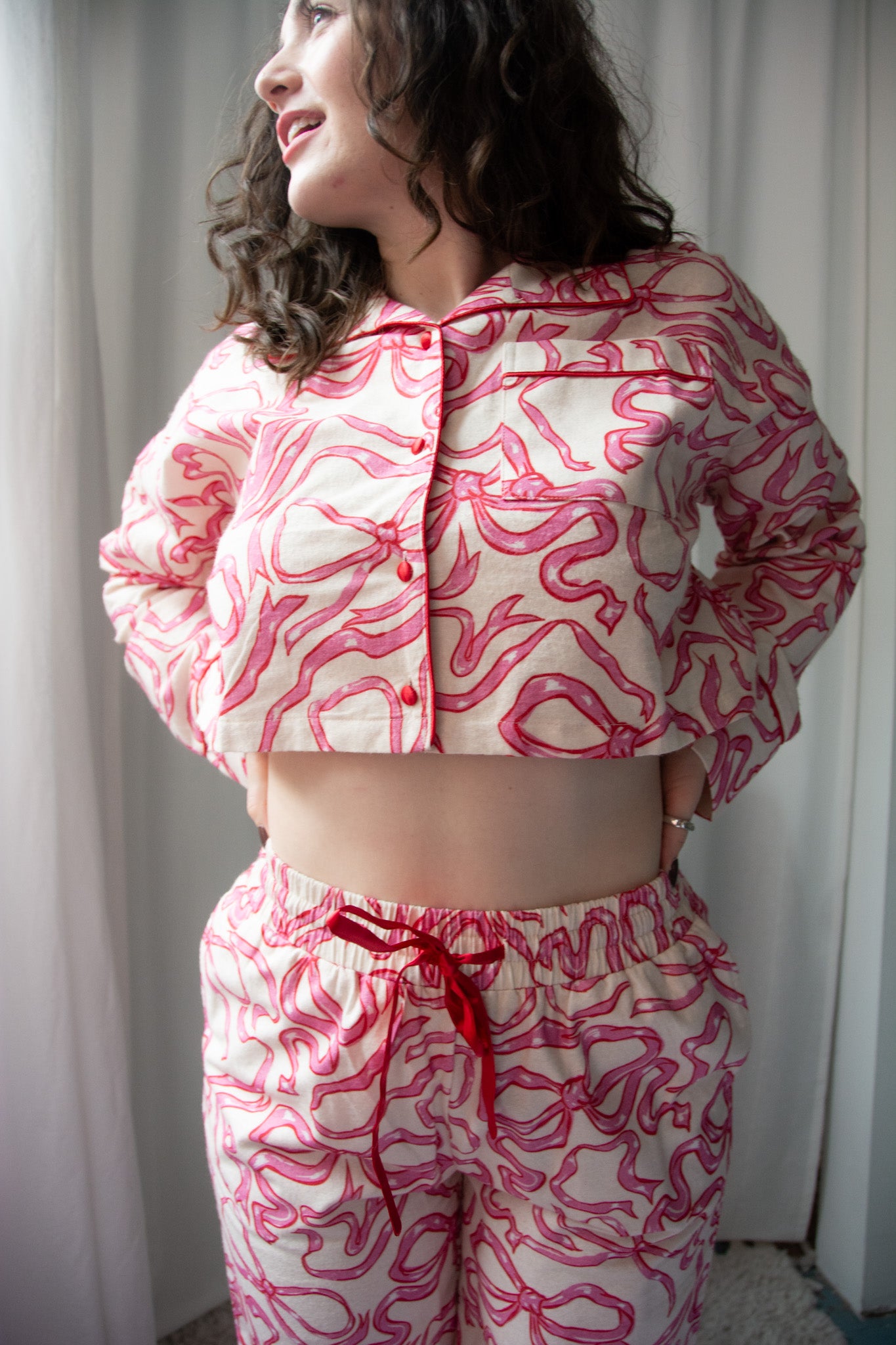Person wearing a pink and white patterned outfit with a red drawstring.