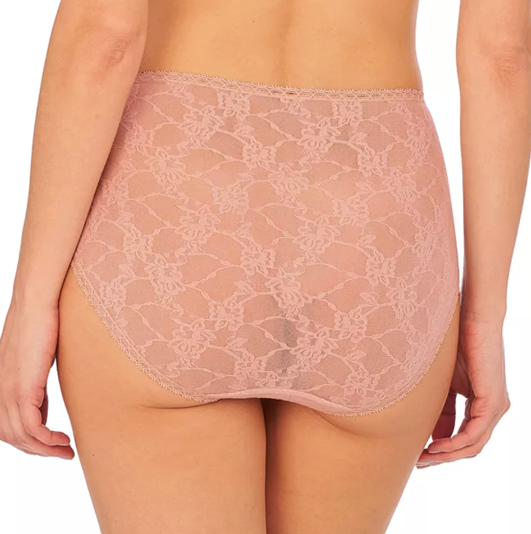 Rear view of a model wearing high-waisted, sheer floral lace panties in a dusty rose pink color, set against a plain white background.