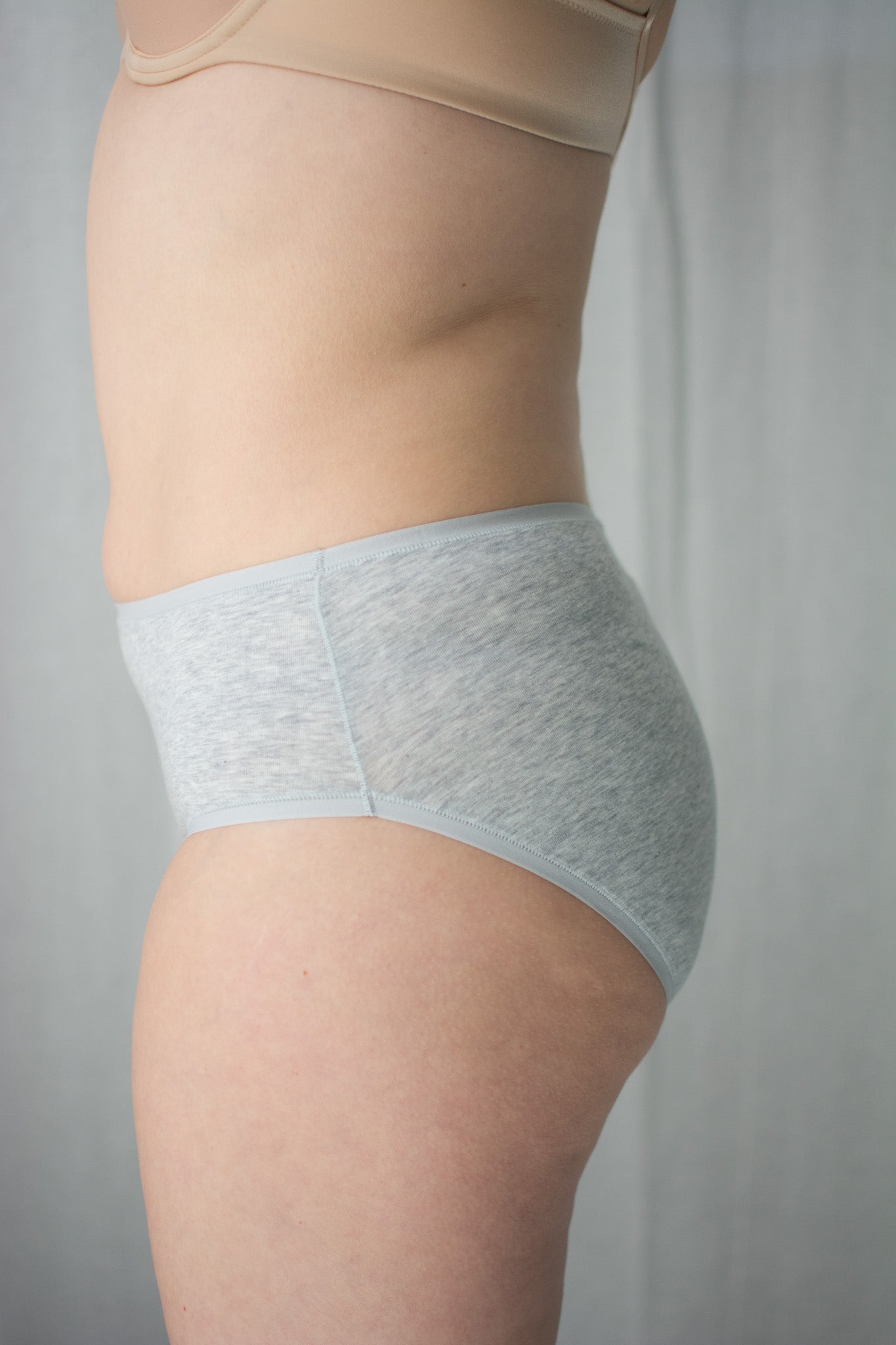 Light gray underwear worn by a person on a plain background