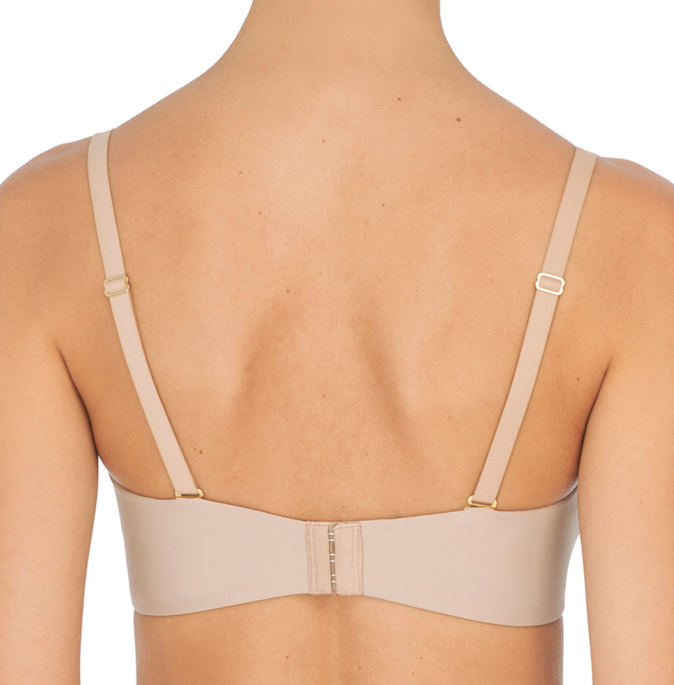 Person wearing beige bra against a neutral background
