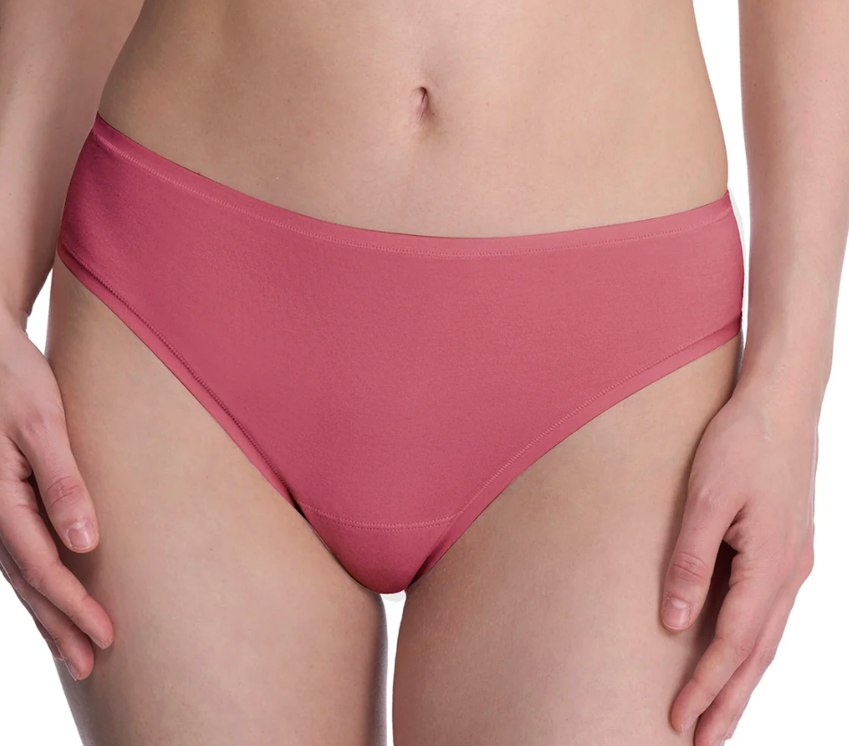 A close-up of a model wearing a solid dusty rose pink bikini bottom against a clean white background.