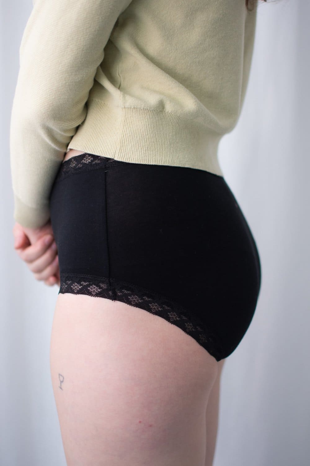Natori Bliss full brief in black, side view on a model, close-up.