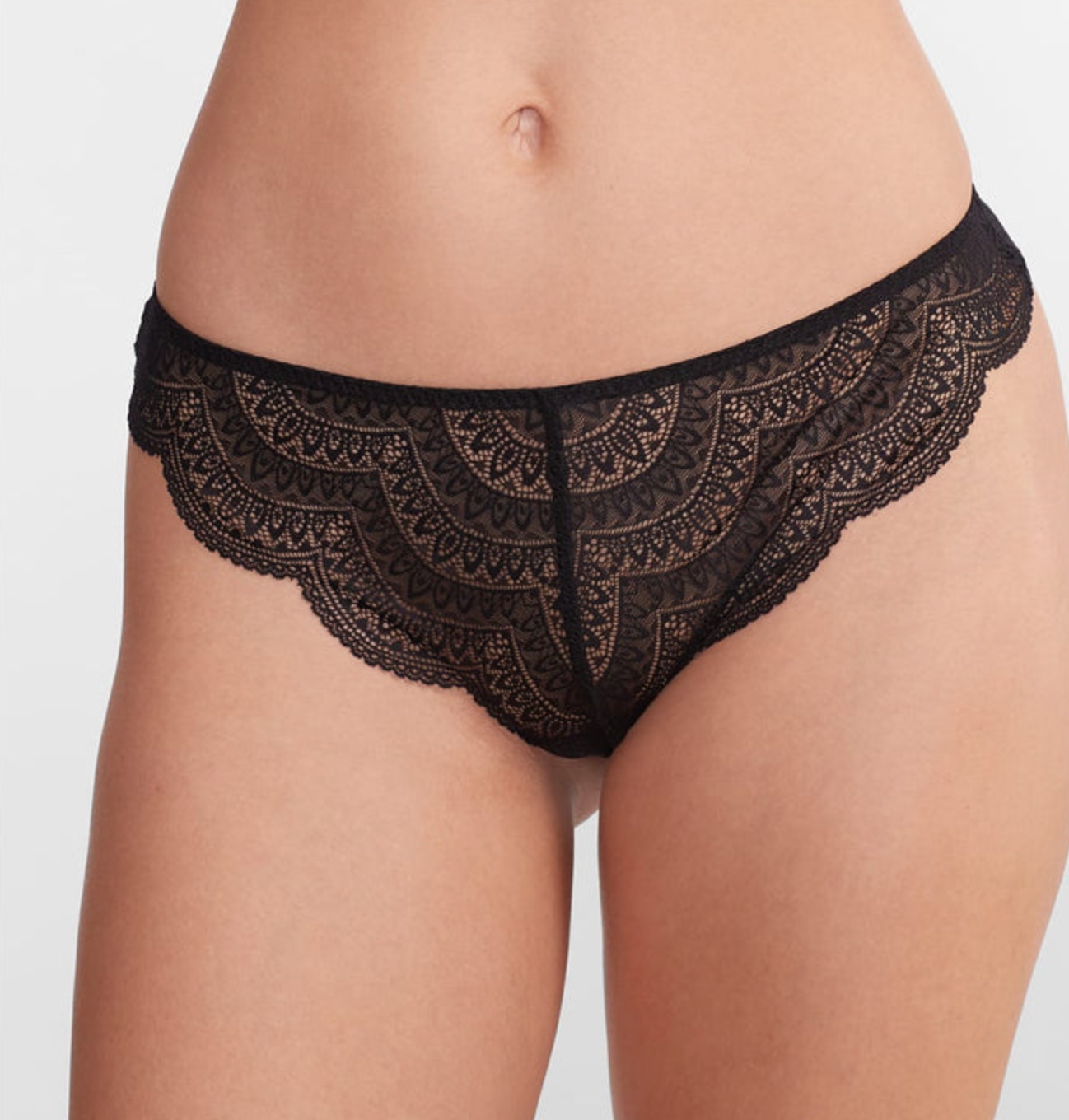 person wearing black lace thong against a white background.
