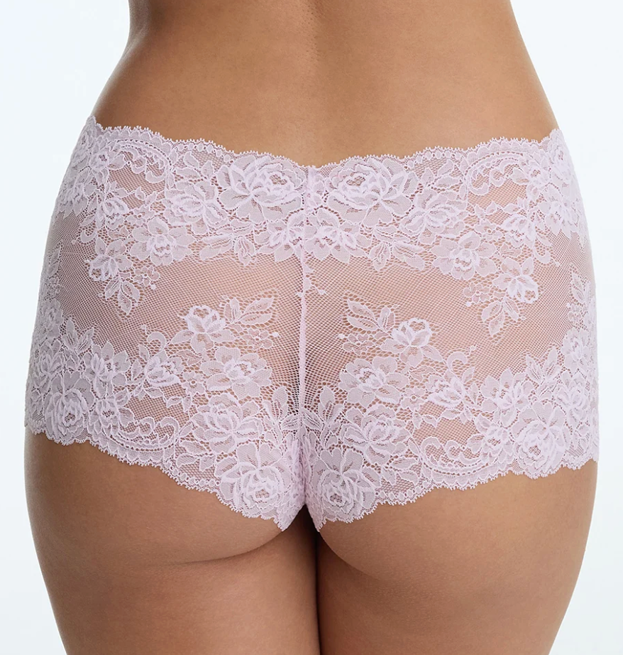 Rear view of a model wearing light pink floral lace panties against a plain white background.