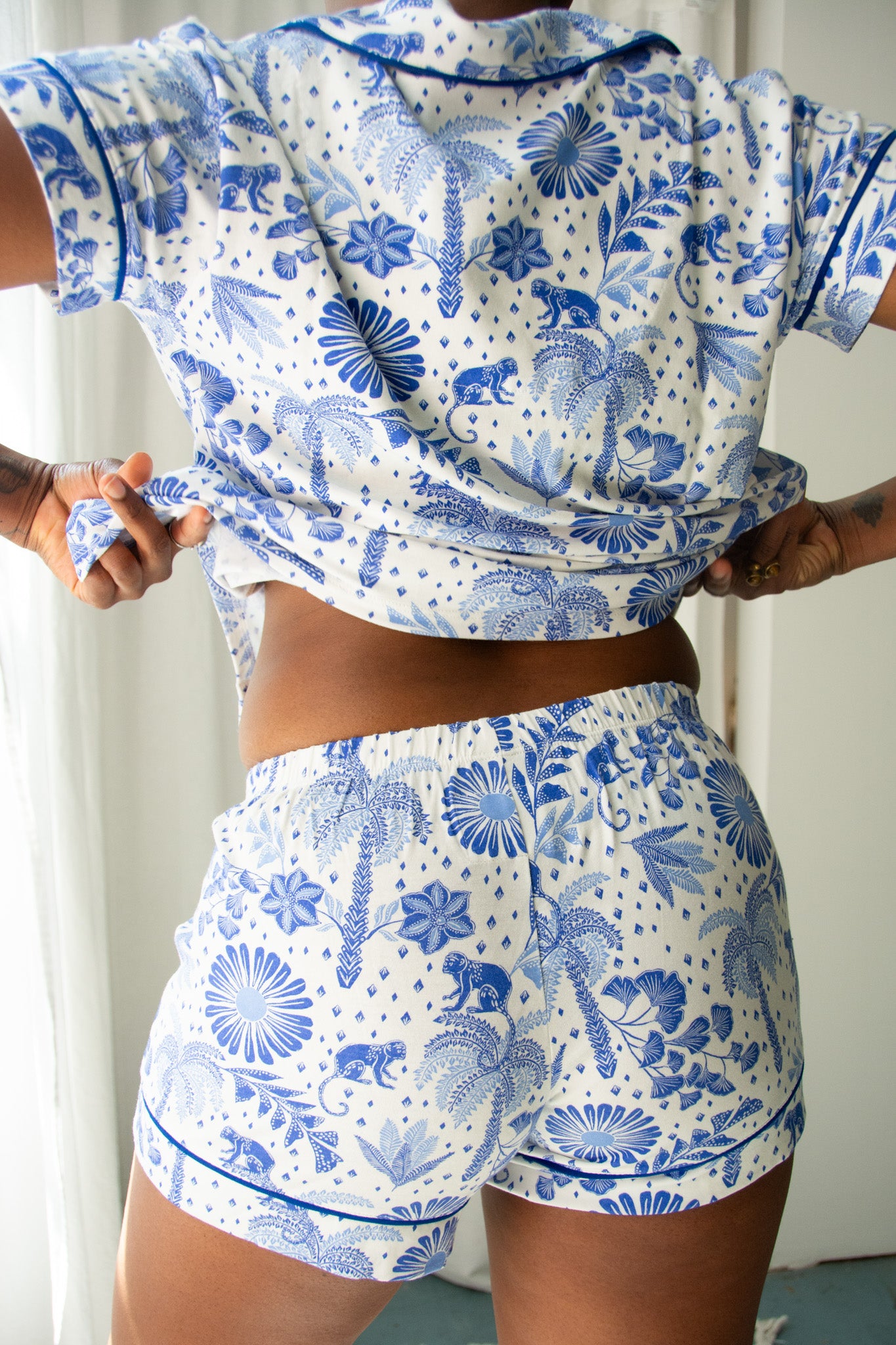 Person wearing a blue and white floral patterned outfit against a neutral background