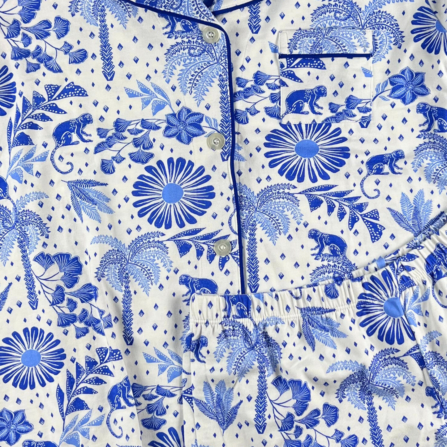 Blue and white patterned shirt with floral and animal designs