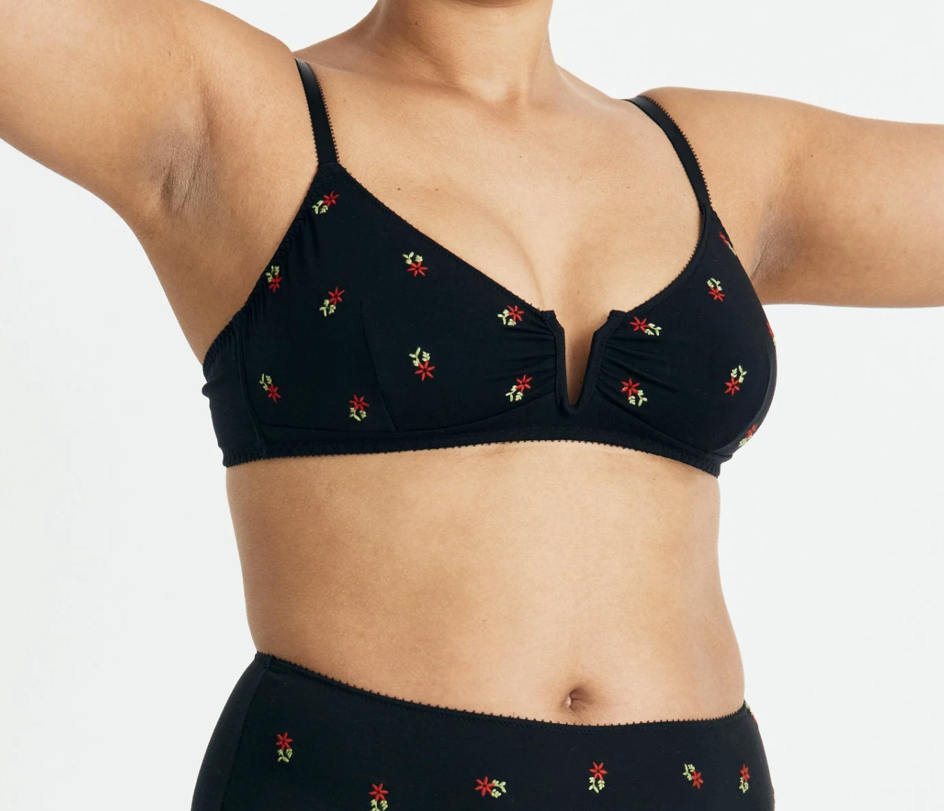Black bikini top with floral embroidery on a white background