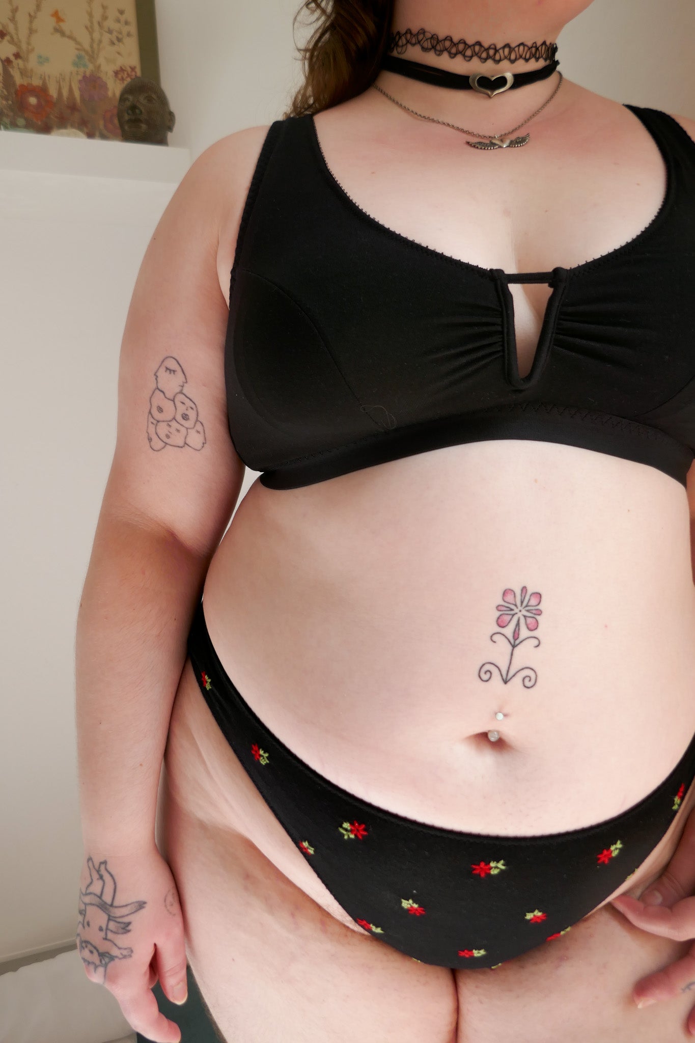 Woman wearing a black bra and underwear set in a room.