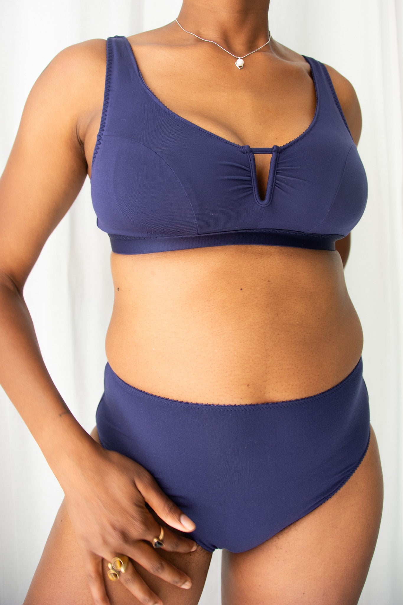 Person wearing a navy blue bikini set against a white background