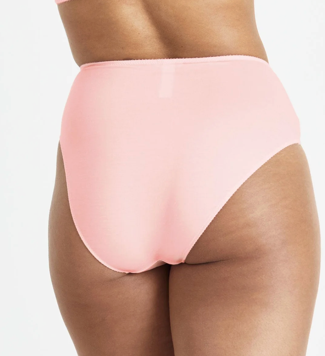 A close-up rear view of a model wearing high-waisted light pink underwear against a plain white background.