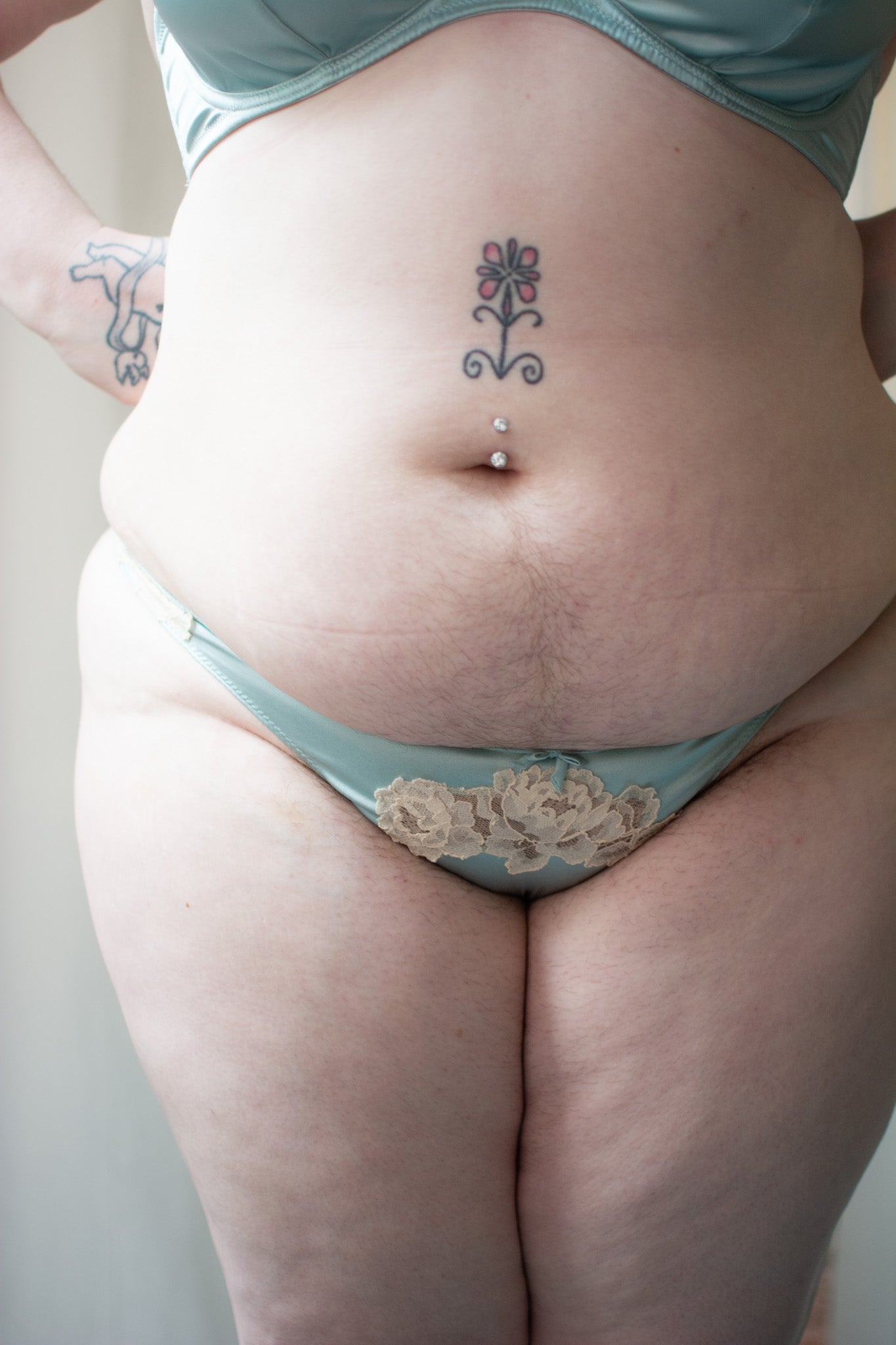 Person wearing light blue underwear with floral details on a plain background