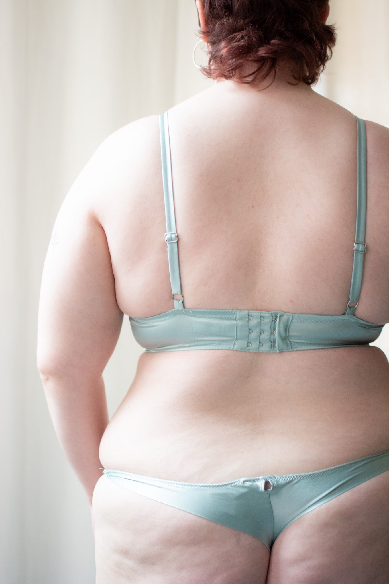 Person wearing a light blue bra and panties set against a neutral background
