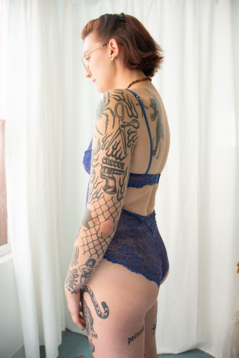 Samantha chang all lace bodysuit in lapis, side view on a model.